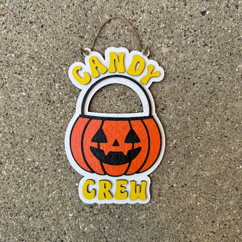 Halloween-themed decoration with 'Candy Crew' text on a textured surface